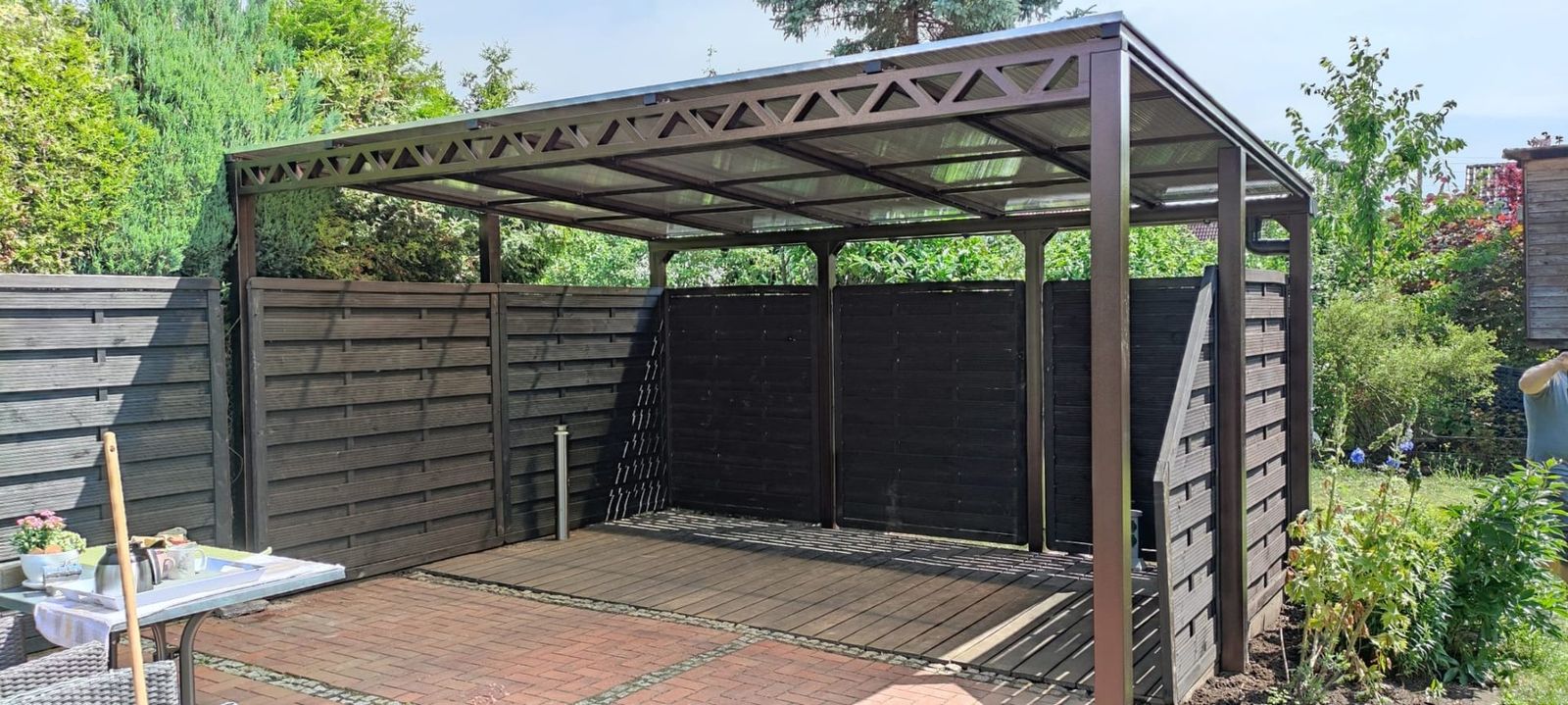 Stahlcarport mit Fachwerkträgern und Sichtschutzwänden